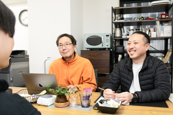 テーブルを挟んで会話する社員