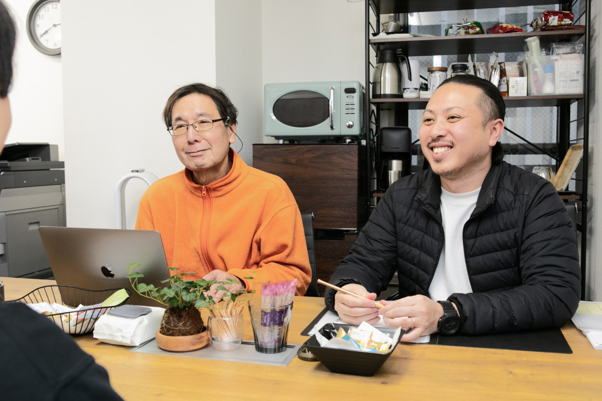 テーブルを挟んで会話する社員