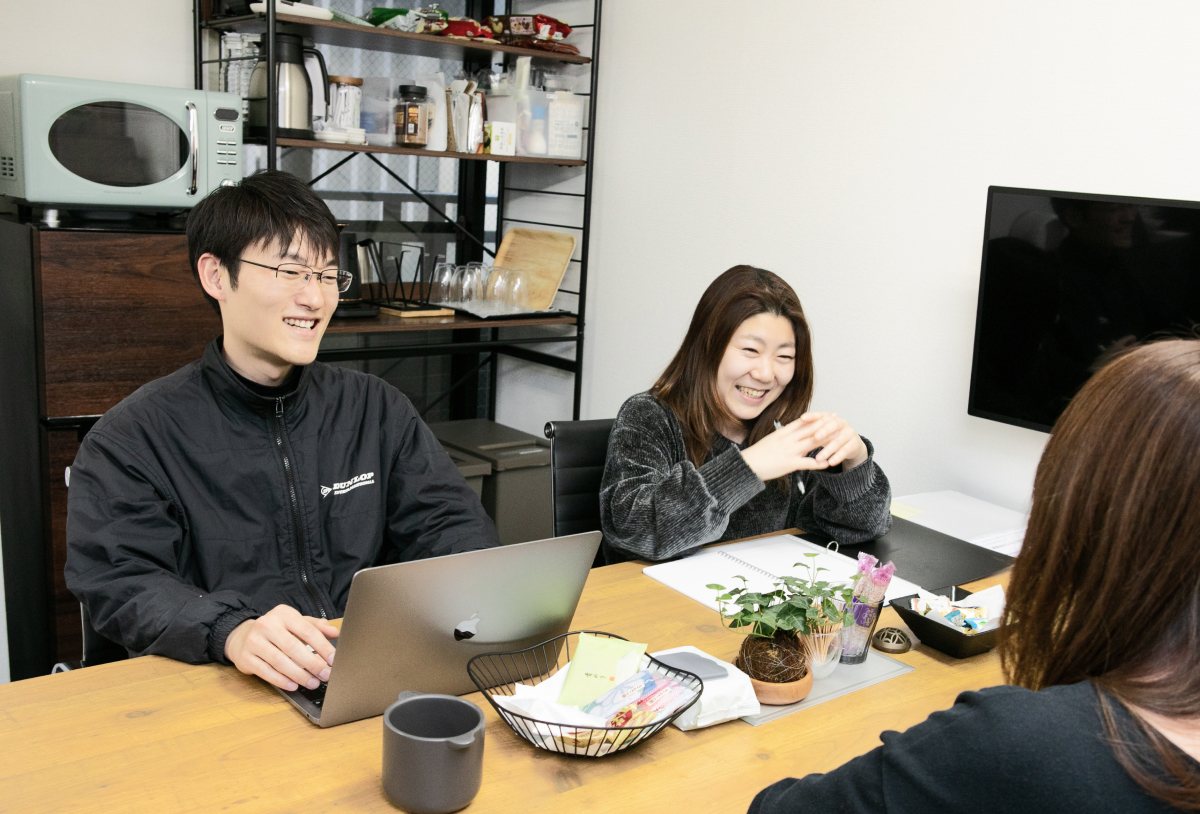 テーブルを挟んで談笑する社員